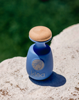 Klea natives Olivenöl extra Galani blaue Keramikflasche mit Holzdeckel steht auf Naturstein im Außenbereich