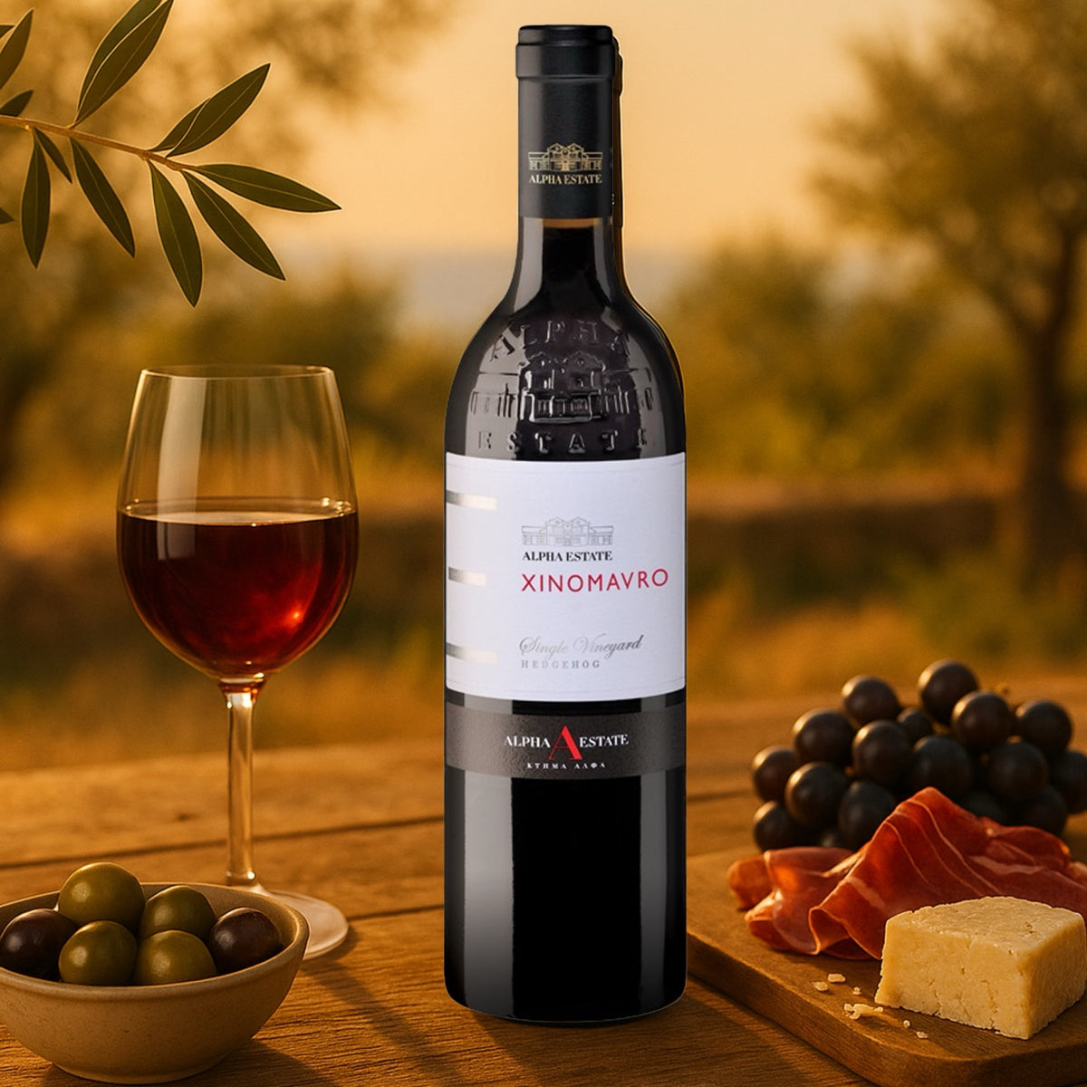 Alpha Estate Xinomavro Rotwein aus Griechenland, serviert mit Rotweinglas, Oliven, Trauben und Käse auf einem Holztisch.