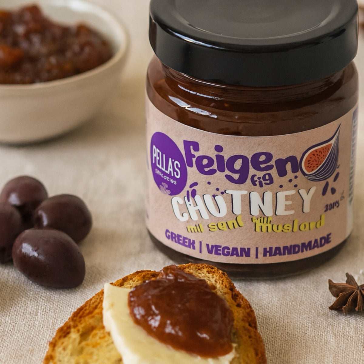 Pellas Feigen-Chutney mit Senf auf geröstetem Brot mit Käse, daneben dunkle Oliven und Sternanis.