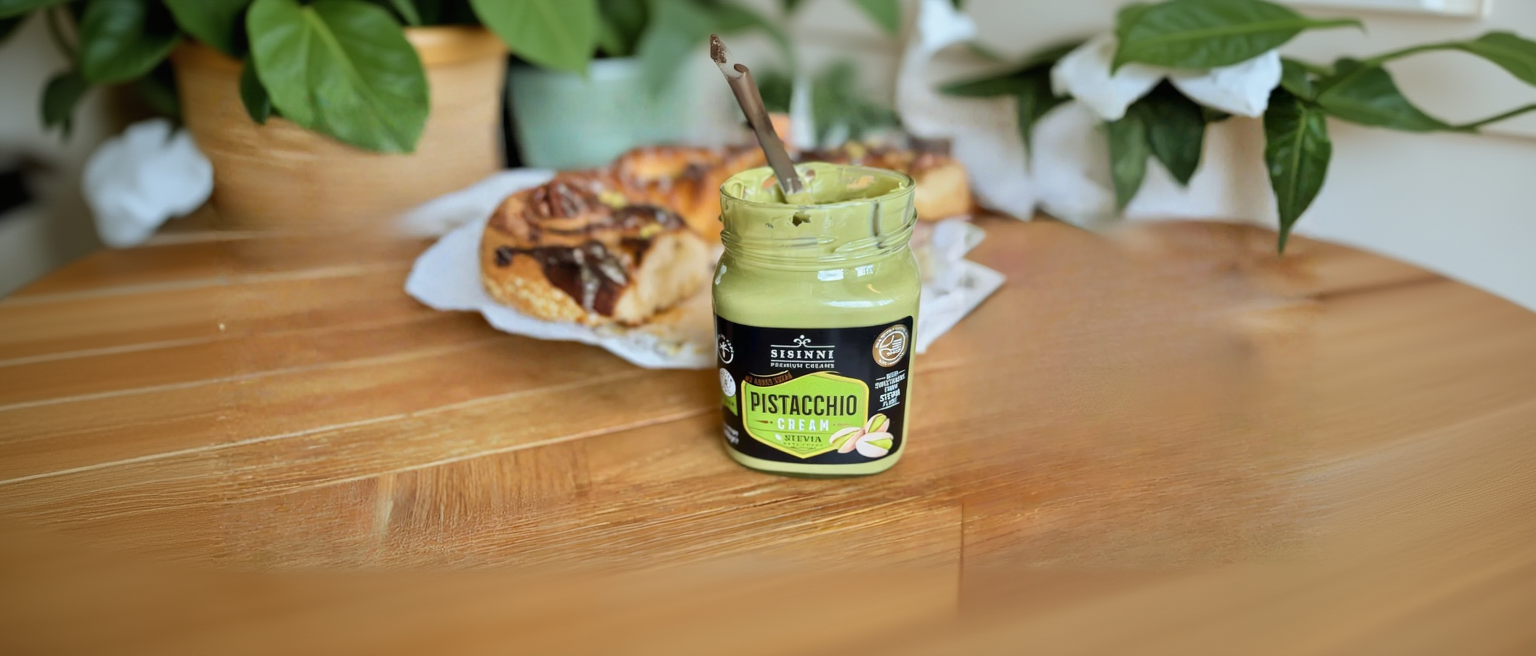 Pistaziencreme mit Löffel und Brot im Hintergrund