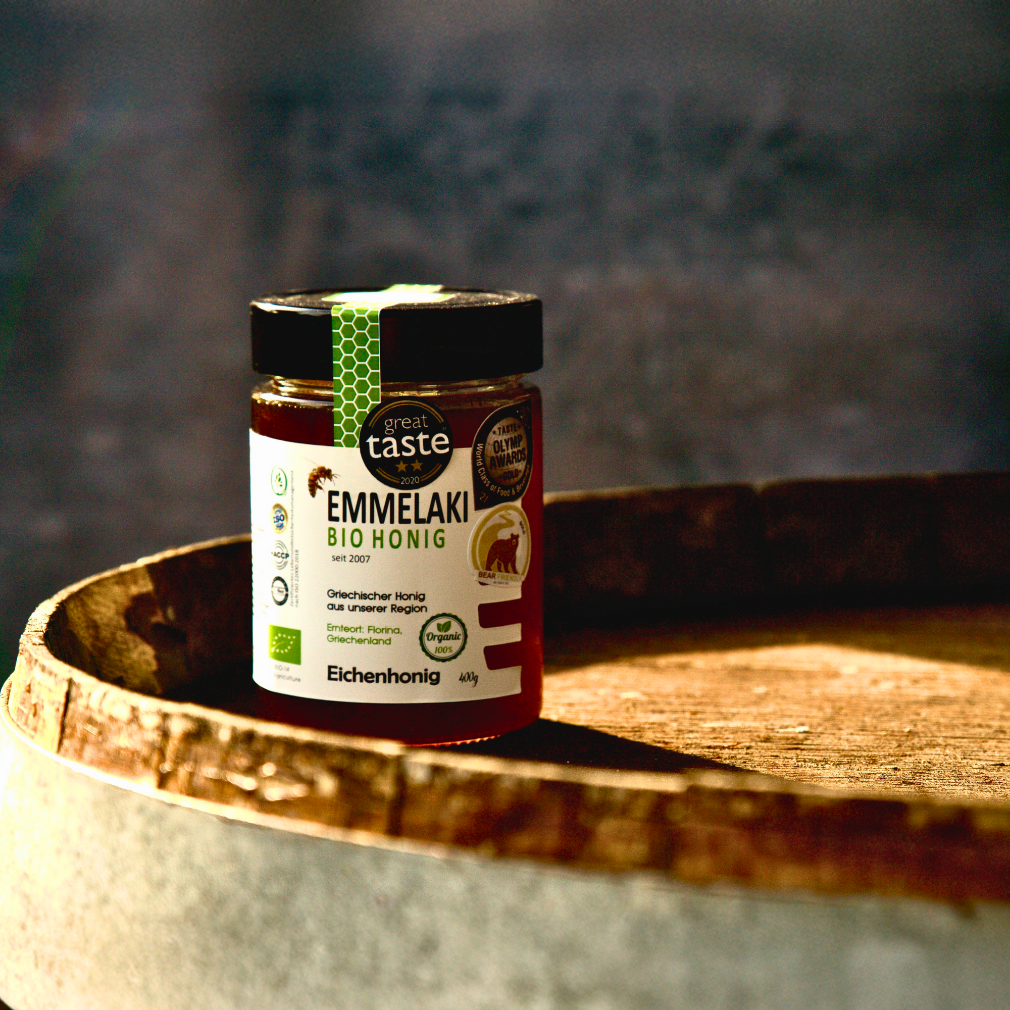 Griechischer Bio Eichenhonig im Glas auf Eichenfass natürlich angerichtet