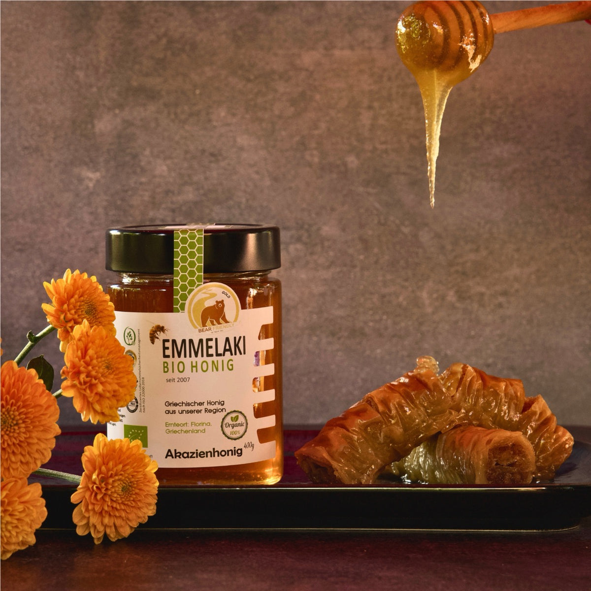 Griechischer Bio Akazienhonig von Emmelaki mit Honiglöffel, Baklava und Blüten, Premium Honig aus Griechenland für Desserts und Frühstück