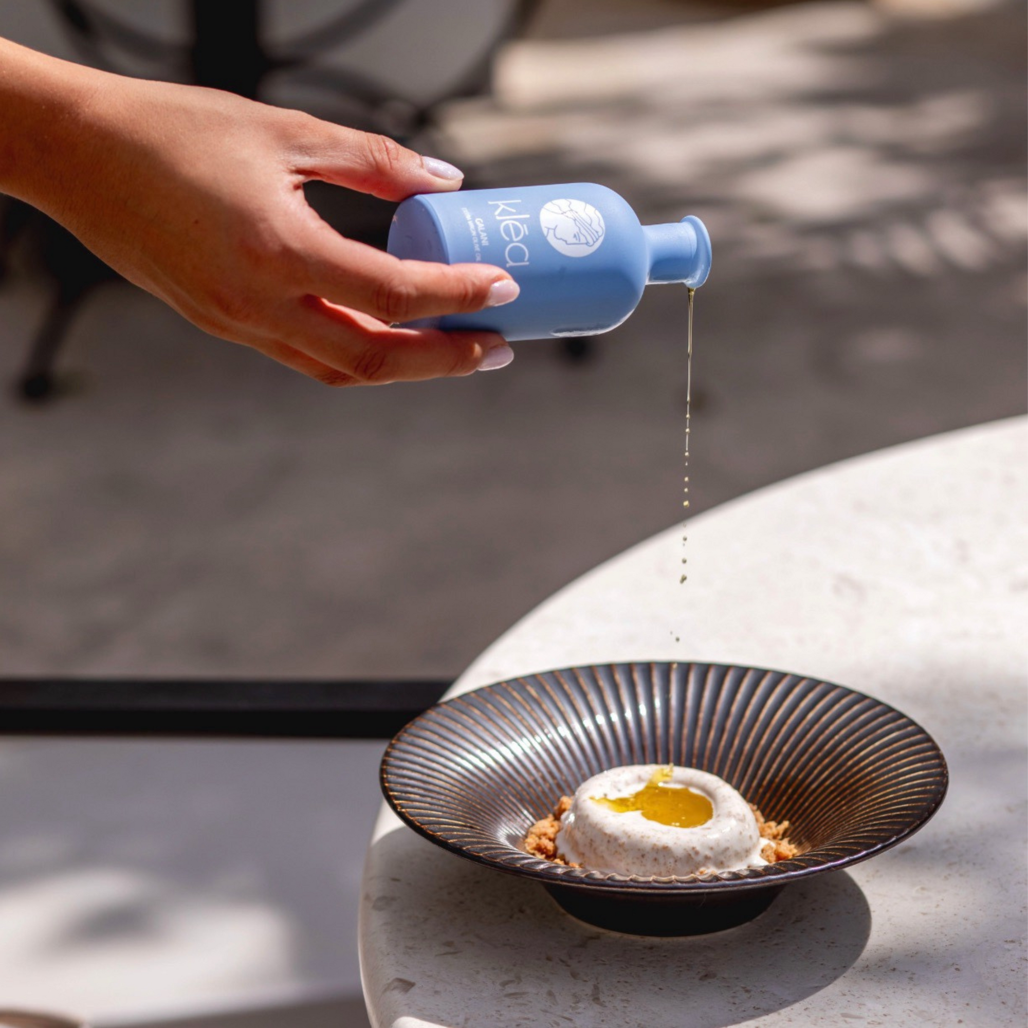 Griechisches natives Olivenöl extra Galani von Klea Flasche wird über essen geträufelt Premium Olivenöl aus Griechenland