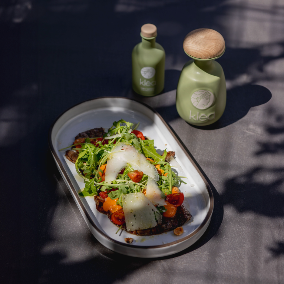 Griechisches Gericht mit Rucola, Parmesan und Tomaten, verfeinert mit nativem Olivenöl extra Klea Frühernte aus Griechenland