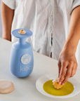 Klea natives Olivenöl extra Galani in blauer Keramikflasche neben Teller mit Olivenöl und Brot zum Dippen