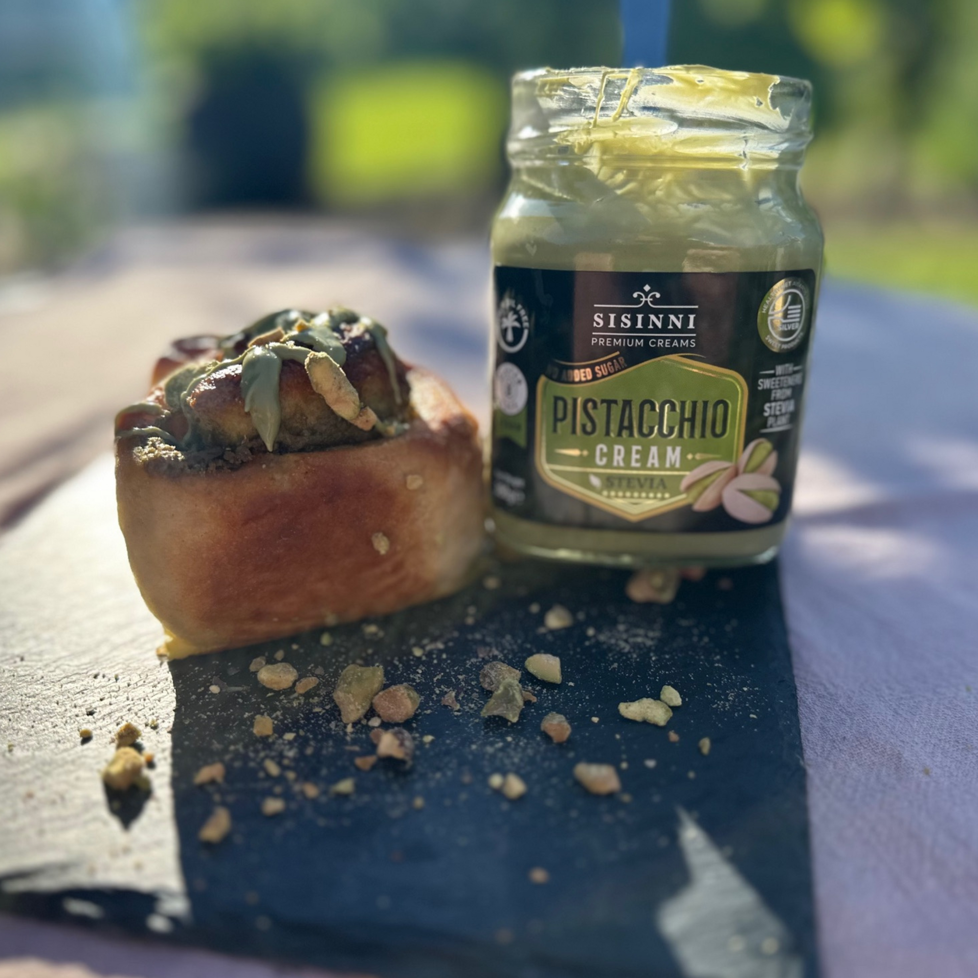 Pistaziencreme zuckerfrei ohne Palmöl vegan im Glas neben Pistazien Gebäck Outdoor Anwendung